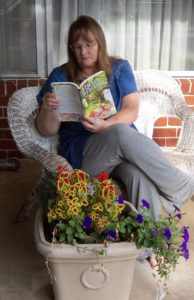 Dawn, reading her mother's-in-law latest mystery, Grave Heritage.